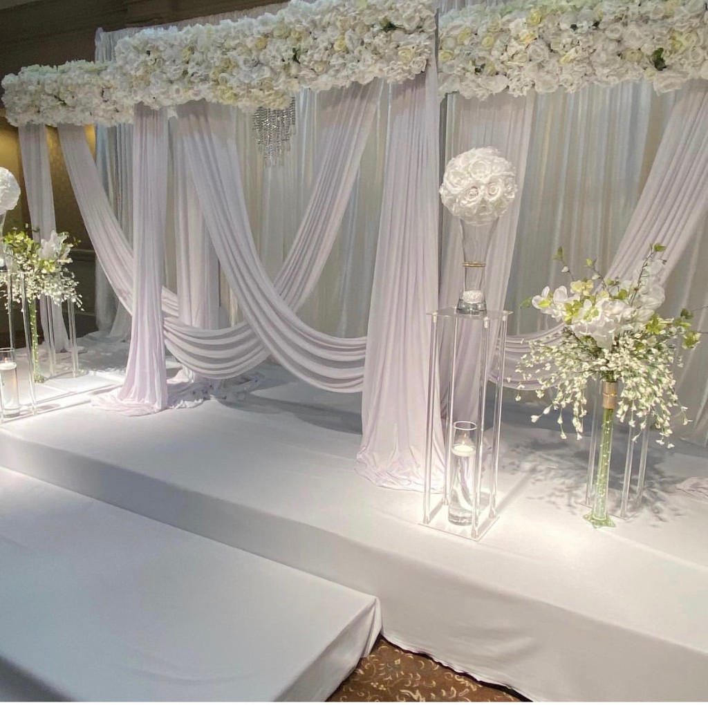 White draped ceremony stage with florals